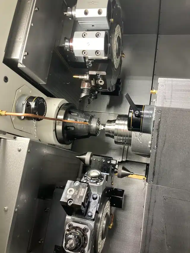 Multi-turret CNC lathe setup showing excellent tool access on a production part optimized with Design for Manufacturability CNC